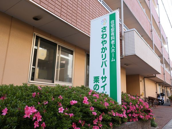 花と看板のある外観