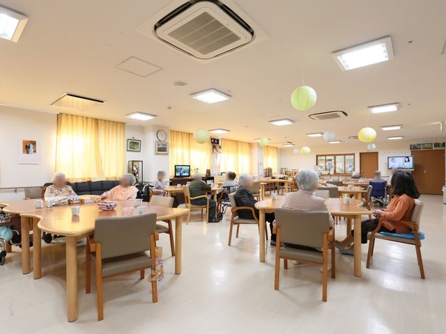 ゆったりとした共有スペース 食堂 明るい照明と広々としたダイニングスペースです。ゆとりのあるテーブル配置で、利用者の皆様が心地よい時間を過ごされています。
