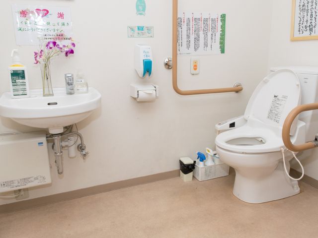 バリアフリー対応の洗面台とトイレ 共用トイレ 手すりと広々としたスペースのある清潔なトイレです。ゆったりとした動線で日々の快適な使い心地を実現しています。