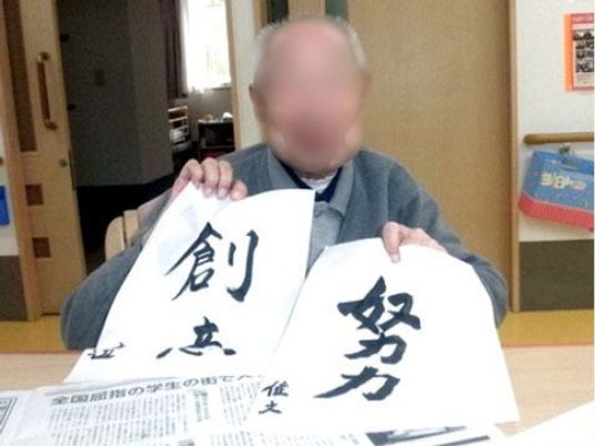 書道作品を披露する人