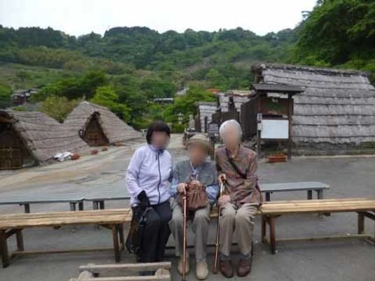 三人の高齢者がベンチに座る