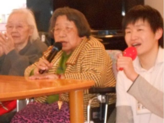 笑顔の集いのひととき レクリエーション 笑顔あふれる居心地の良い空間で、利用者とスタッフが楽しい時間を共有しています。歌や会話で交流を深め、温かいコミュニティを築いています。