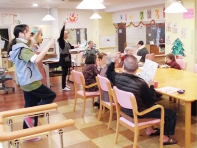 活動の様子が見える居室 レクリエーション 居室で過ごす方々が楽しげな雰囲気の中、さまざまな活動に取り組んでいます。スタッフとのコミュニケーションも和やかで、皆さん笑顔で過ごしている様子が窺えます。