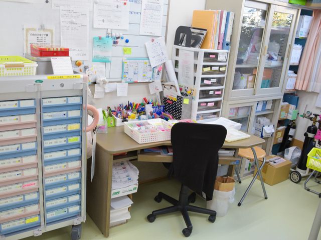 事務所の風景 スタッフルーム 整理された物品や書類が多数ある忙しいスタッフの事務スペースです。日々の業務で活用される様子が伝わります。