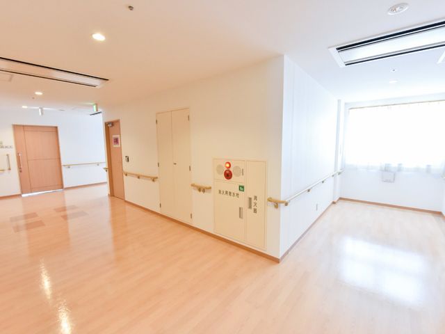 明るく清潔な多目的室 廊下 広々とした明るい多目的室では、日常の活動が快適に行えます。壁に沿った手すりが安全な移動をサポートしています。