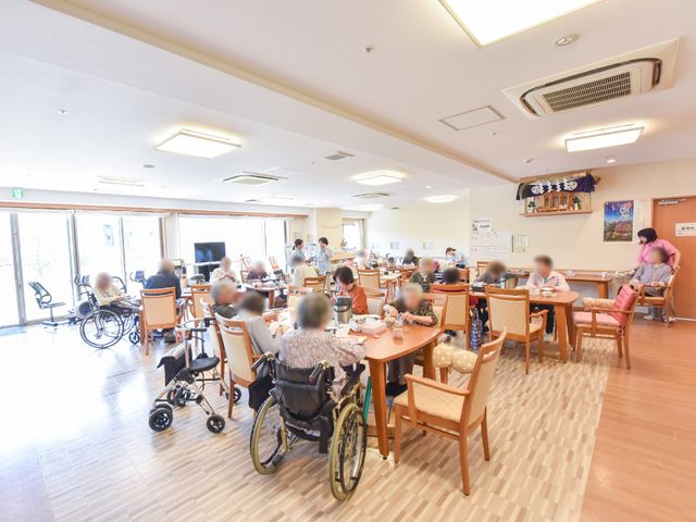 共有スペースの日常風景 共有スペース1 明るく広々とした食堂で、利用者の方々が食事やお話を楽しんでいます。快適な日々をサポートするやりがいを感じられる場所です。
