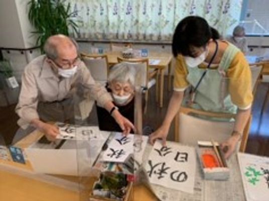 書道を楽しむ利用者とスタッフ