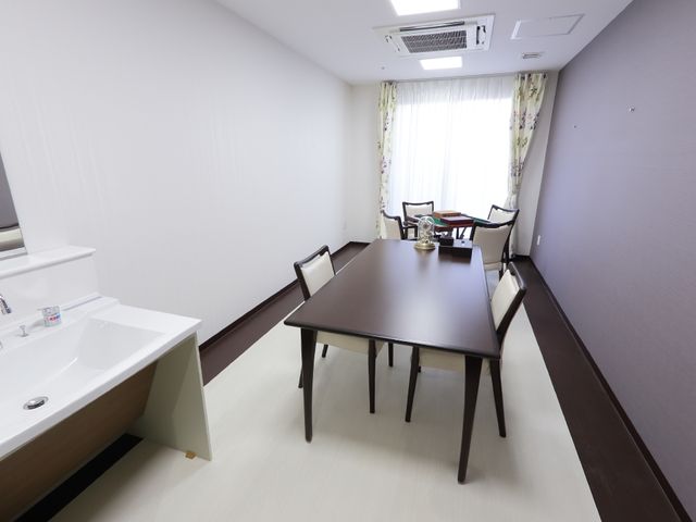 居室のテーブルと洗面台 談話室 ゆとりのある居室です。テーブルでの読書や、洗面台も備えており、快適な毎日を過ごせます。