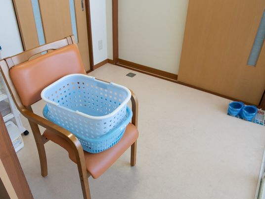 椅子と洗濯カゴのある居室