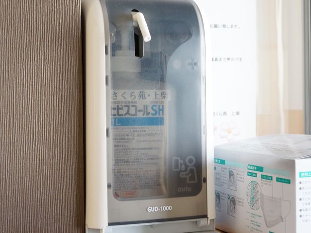 手指消毒器具のクローズアップ 設備 手指衛生を助ける消毒剤自動ディスペンサーが設置され、働く環境の清潔を保持しています。
