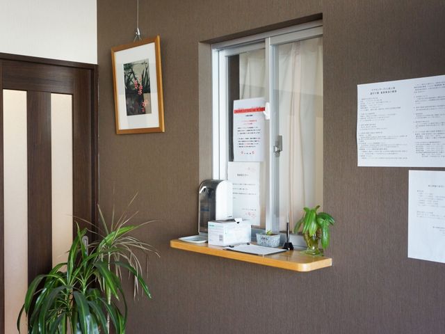 受付と掲示物のある廊下 受付 明るく落ち着いた雰囲気の受付エリアです。上質な待ち時間を提供する配慮が感じられます。