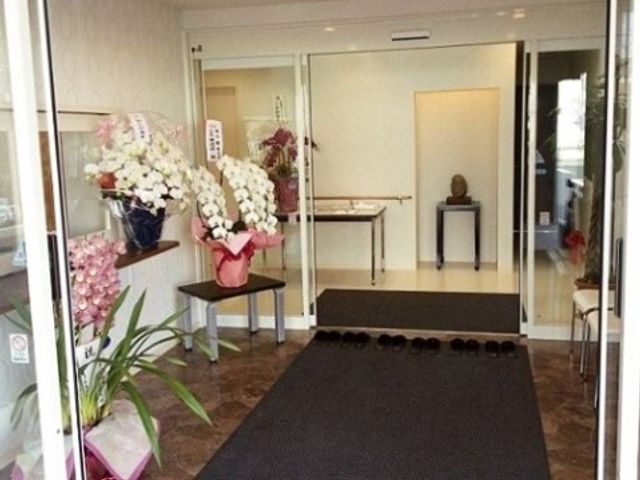 エントランスの花とマット エントランス お出迎えの花が彩るエントランスは、来訪者を暖かく迎えています。スタッフとして優しい雰囲気を感じていただける場所です。