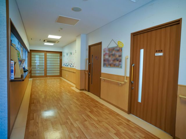 廊下の明るい空間 内観 清潔感にあふれた廊下で、壁には楽しげな装飾が施されています。スタッフや利用者の方々にとって快適な移動を支援する設計がなされております。