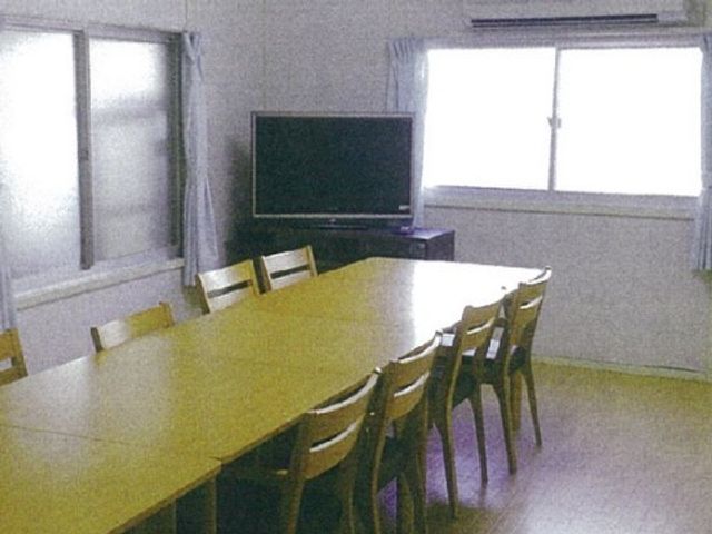会合用テーブルのある部屋 リビング 広々とした明るい多目的室で、テレビや会議を楽しむ空間が整っており、集いの場としても適しています。