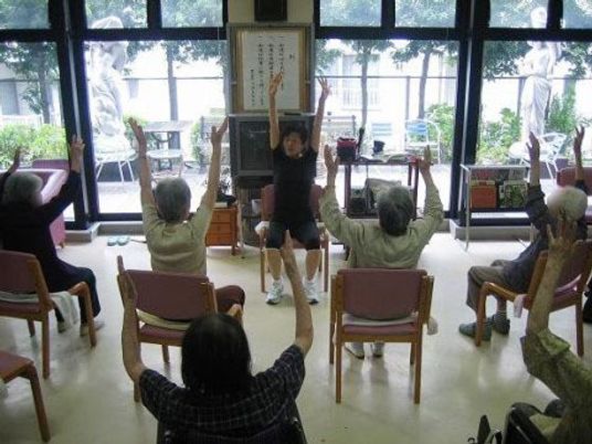 運動するシニアと指導員