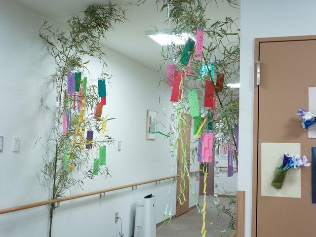 七夕飾りのある廊下 廊下 廊下に色とりどりの短冊が飾られ、季節の行事を楽しむ暖かな環境が整っています。慣れ親しんだ風習が心地よいひとときを提供します。