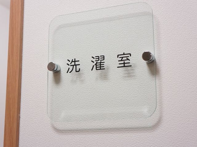 壁掛け式の洗濯室看板 洗濯室 清潔感のある壁に表示された「洗濯室」の標識は、日々の暮らしに欠かせない設備への案内役です。
