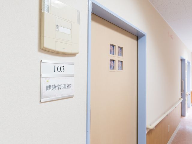 廊下と部屋の番号 健康管理室 明るく清潔感のある廊下で、ゆったりとした手すりが整っており、安心して過ごせる環境です。