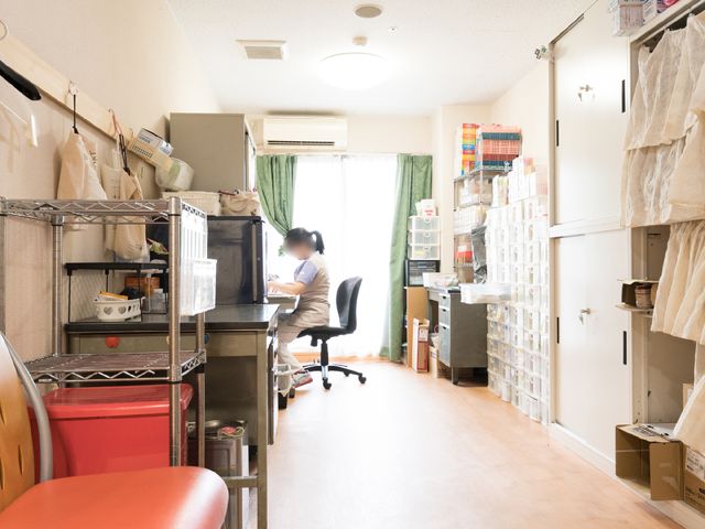 スタッフが作業する居室 スタッフルーム スタッフの方がデスクワークをされている居室です。整理された物品と光が差し込む窓が印象的です。