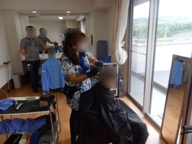 理美容室での作業風景 訪問理美容 スタッフの笑顔が心地良い、清潔感のあふれる理美容室です。明るい採光のもとで、利用者様の身だしなみを整えます。