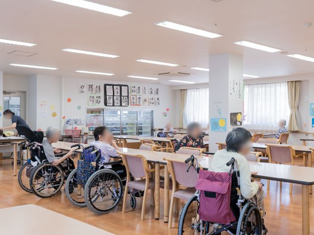 明るい共用ダイニング コミュニティリビング 広々としたダイニングルームでは、入居者の皆様が食事やコミュニケーションを楽しんでいます。ゆったりとした時間を過ごす場としても最適です。