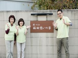 スタッフと看板の前