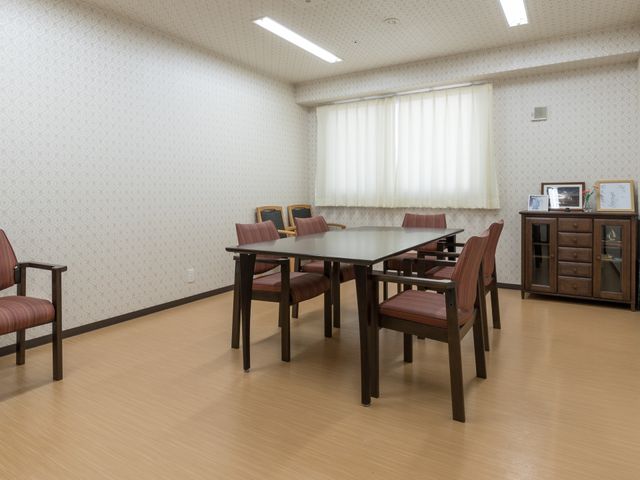 居室の家具と広さ 相談室 ゆったりした居室の一角には、落ち着いた色合いの家具が配置され、日々の交流や自由なリラックスタイムを過ごすためのスペースがあります。