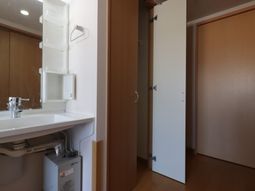 洗面台と開いた扉の部屋