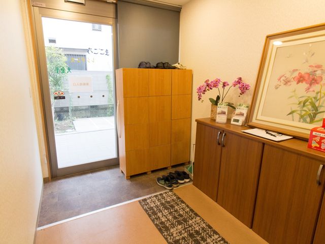 玄関と靴箱のあるエントランス 玄関 心地良い明るさのエントランスです。訪れる方々を温かく迎える装飾が施されています。