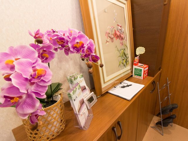受付カウンター装飾細部 玄関 心を込めたお花の飾りが、やすらぎの空間を演出しています。訪れた方々の第一印象を温かく迎えます。