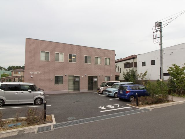 駐車スペースのある建物 外観 駐車場を完備した落ち着いた色合いの建物です。快適な職場環境を探している方にとって、見学に値する施設かもしれません。