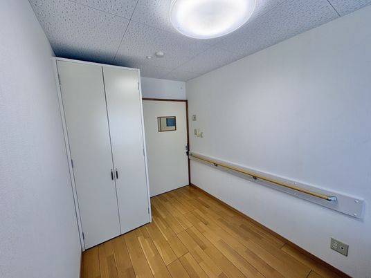 白い家具と手すりの居室