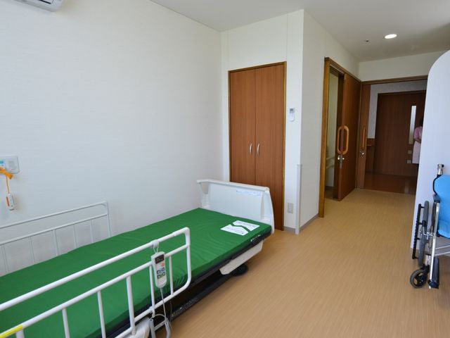 居室の清潔な空間 居室1 広々とした居室です。ベッドの横には十分なスペースがあり、快適な生活空間を提供しています。