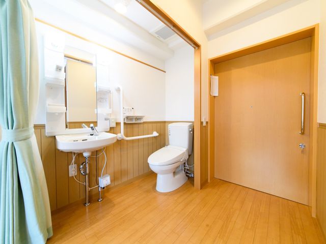 手すり付きの清潔なトイレ トイレ 広々としたバリアフリーのトイレは、手すりが完備され安心してご利用いただけます。デザインも落ち着いた色合いで、居心地の良い空間となっています。