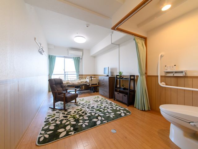 居心地の良い居室空間 居室 ゆったりとした居室には、快適な椅子やテレビが配置され、自分の時間を大切に過ごせる環境が整っています。安全のための手すりも備え付けられており、機能的な空間です。