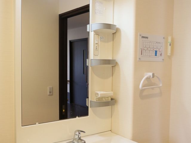 洗面所の設備一式 洗面台 手すりが備わった洗面台で、安全に日々の身だしなみを整えることができます。明るい色合いで統一された清潔感のある空間です。