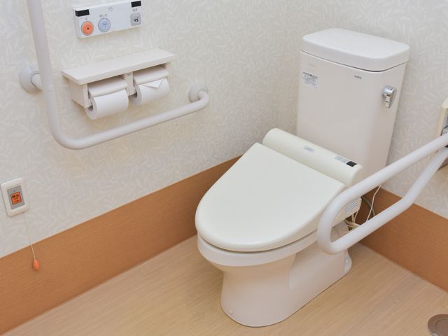 トイレの手すり付き便器 トイレ 安全に配慮された手すり付きのトイレです。必要時には緊急コールも使用でき、安心してご利用いただけます。