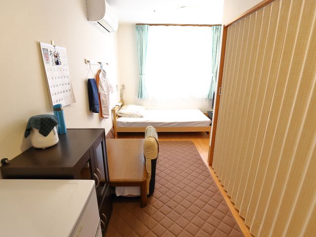明るい個室の居室 居室 居心地の良い個室で、自分のペースでゆっくり過ごせる空間です。日光が差し込み、暖かな雰囲気が漂っています。