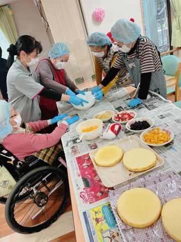 料理活動をする笑顔の集い キッチン スタッフの支援を受けながら、車椅子の方も交えてみんなで料理活動を楽しむ和やかな様子です。