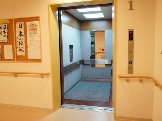 エレベーター内は奥行きがあり、鏡も設置されている。また、左手には掲示板があり、書道の作品も張り出されている。