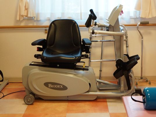壁際には、イス付きのマッサージ器が置かれてあり、キャスターもついている。また、奥の方には杖も置かれている。