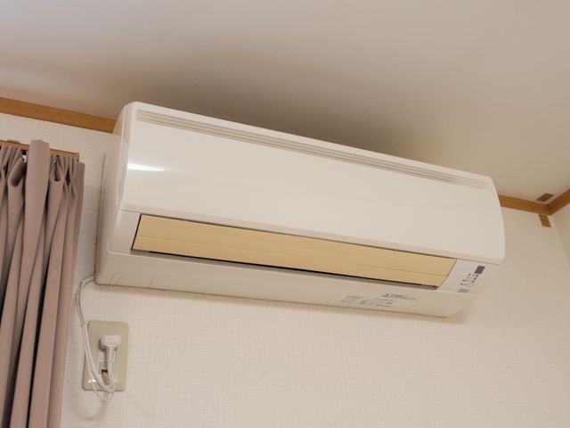 壁掛けエアコンの室内機 空調機器 清潔感のある室内に設置されたエアコンは、一年を通して快適な温熱環境を提供しています。