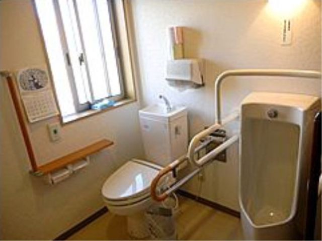 バリアフリー対応の洗面所 共有トイレ 握りバー付きの清潔なトイレです。利用者の自立を支援し、安心してご使用いただける設計となっております。