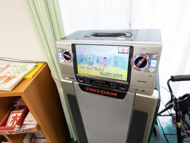 カラオケ機器と雑誌 レクリエーション 歌や音楽を楽しむ設備が整った共有スペースです。趣味の時間を充実させる環境があります。