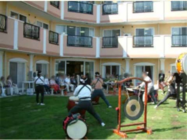 中庭での音楽イベント 生活支援 中庭に集う人々が、活気に満ちた音楽イベントを楽しんでいます。ここでは日々の暮らしに潤いをもたらす様々なアクティビティがあります。