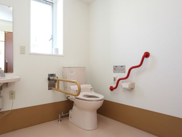 手すり付き明るいトイレ トイレ 明るく清潔感のあるトイレ空間です。手すりが設置され、利用者の安全を考慮した配慮がなされています。