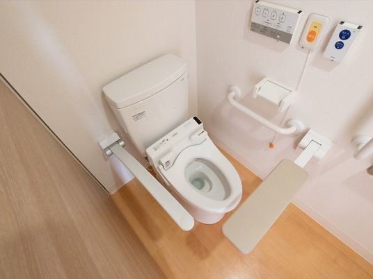 居室内のトイレには可動式の手すりが備えつけられている。便器の近くには呼び出しボタンがあり、緊急時は紐を引くことで外部の人を呼べる。