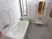 清潔感のある白い壁の浴室には、まんべんなく手すりが備えつけられている。足を伸ばして入れる浴槽が設置されている。