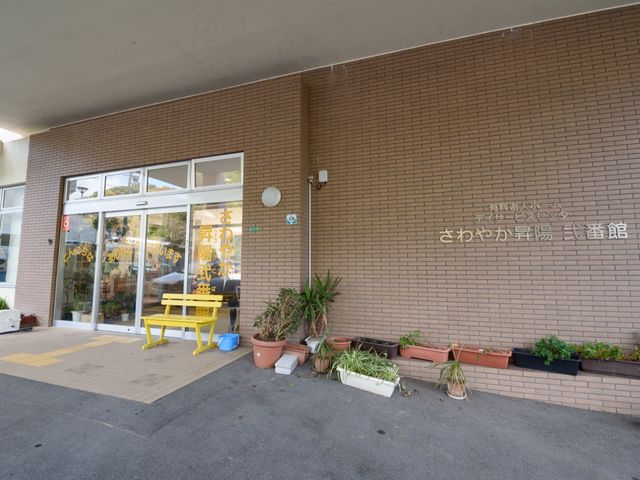 施設の入り口と看板 玄関 明るく開放的なエントランスが迎えてくれます。緑の植物が彩りを添え、温かな雰囲気を生み出しています。