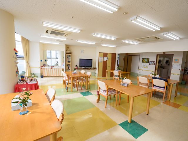 明るい共有ラウンジエリア 食堂 清潔感のあふれる空間で、共有ラウンジではお花を眺めながらゆったりとした時間を過ごすことができます。車椅子でも安心して移動できる広々とした間取りです。